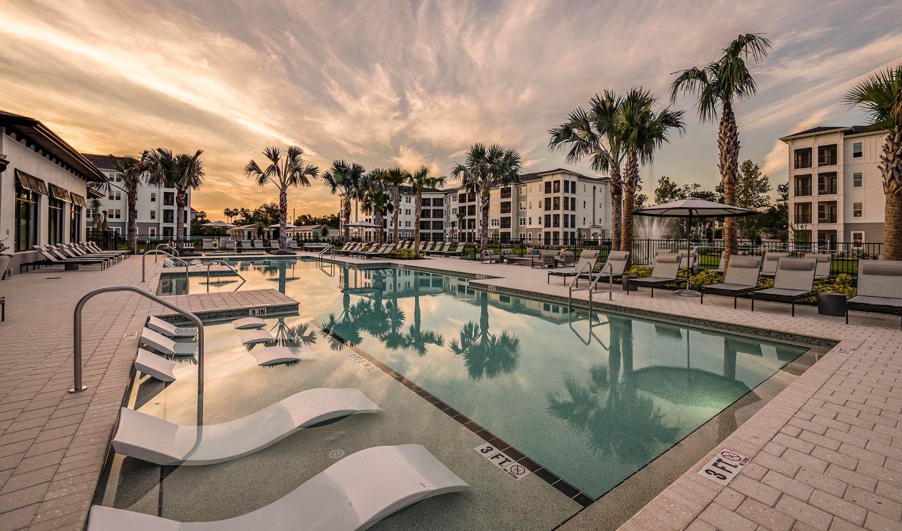 a pool with lounge chairs around it
